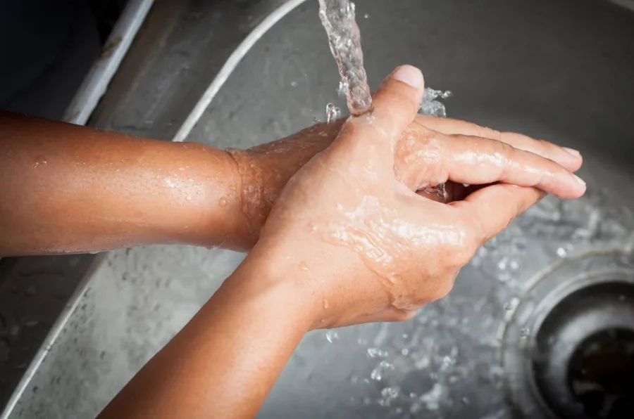 Hands being washed under a running tap